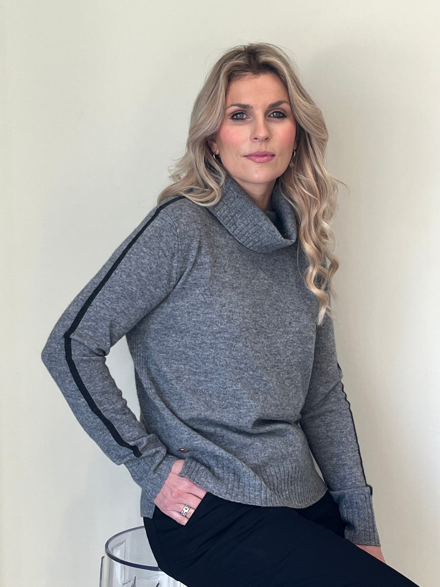 Grey rib detail roll neck with black stripe intarsia detail down the arms 