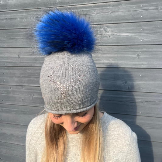 Grey cashmere plain knit beanie with stag embellishment & fur pom