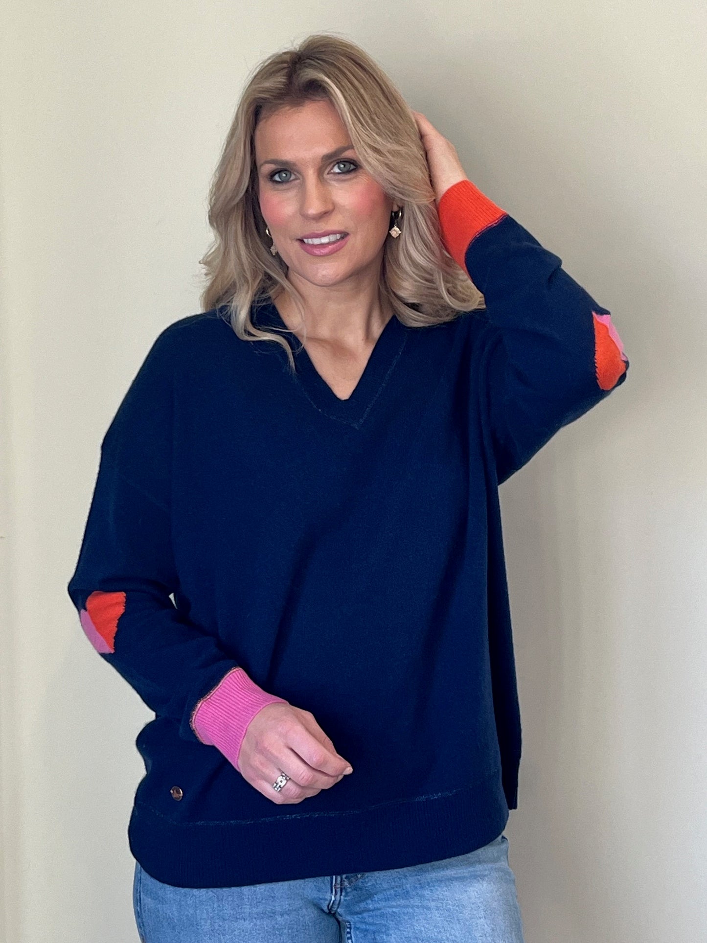 Classic navy boyfriend v-neck sweater with pink and orange heart intarsia elbows and trim to sleeves